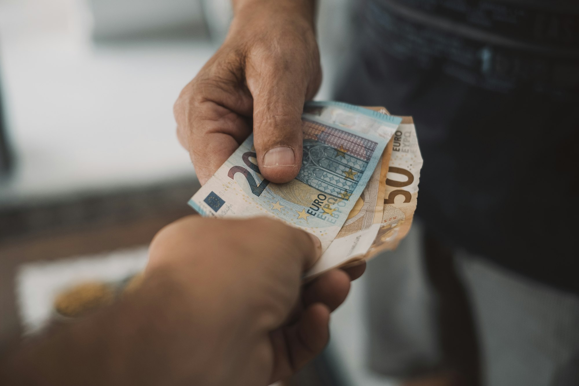 Close up of people exchanging cash banknote money. Concept of giving and taking euros