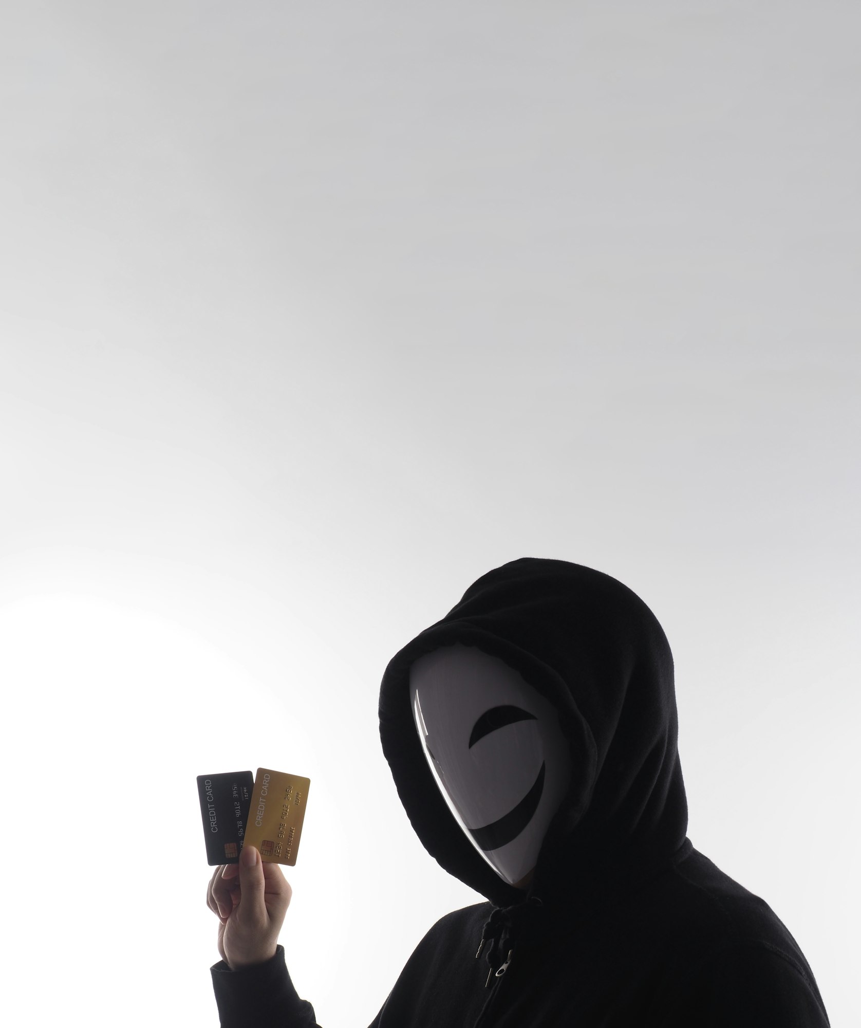 Credit cards personal data stolen by anonymous man in Black hood shirt.