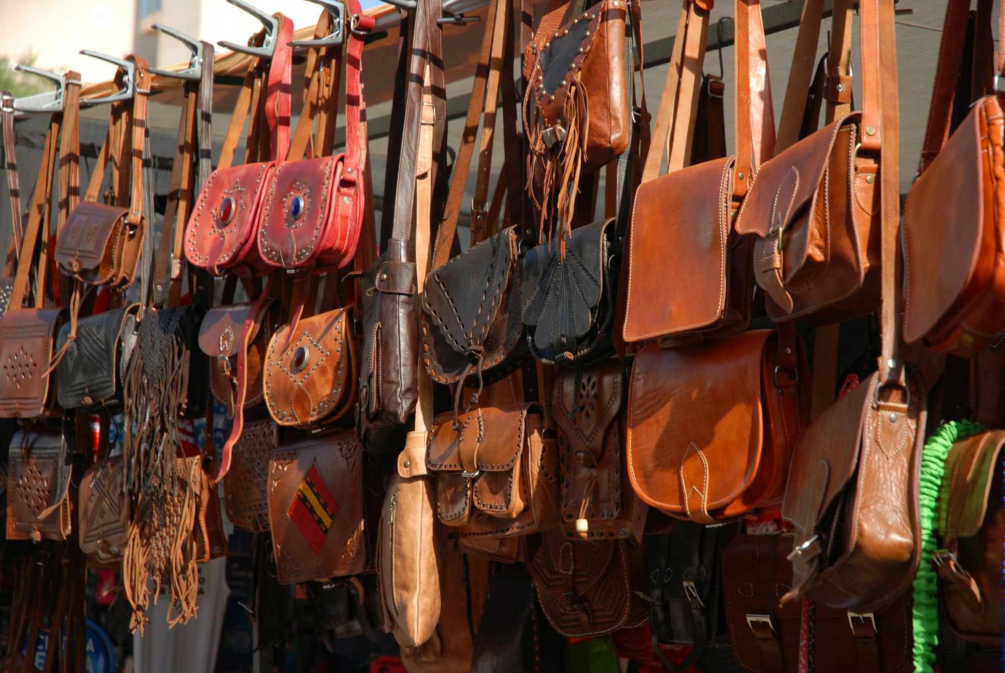 Display of leather bags for sale on an open market stall in Javea, Spain